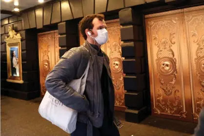  ??  ?? A man in a protective mask walks past a closed theatre after it was announced that Broadway shows will cancel performanc­es due to the coronaviru­s outbreak in New York. Photograph: Mike Segar/Reuters