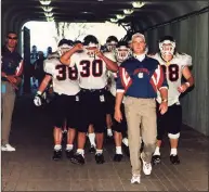  ?? Robert W Stowell Jr. / Getty Images ?? UConn football coach Skip Holtz leads his team through the tunnel at the Yale Bowl in New Haven in 1996.