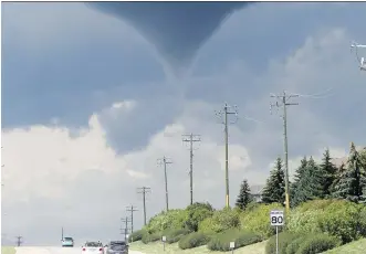  ?? TED RHODES/ CALGARY HERALD ?? A distinct funnel cloud formed over Tsuu T’ina Wednesday afternoon. Environmen­t Canada says the cloud had the potential to become a strong tornado.
