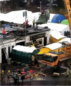  ??  ?? Clear-up: Helicopter wreckage is lifted from the pub