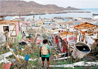  ??  ?? A man looks at the destroyed houses and debris on the Isla de Providenci­a left by the passage of Hurricane Iota, the largest hurricane to ever hit the area