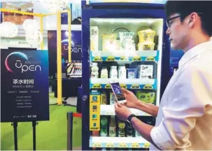  ?? PROVIDED TO CHINA DAILY ?? A man uses Alipay to buy drinks from a retail machine.