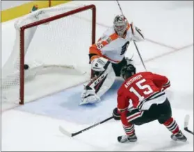  ?? CHARLES REX ARBOGAST — THE ASSOCIATED PRESS ?? The Blackhawks Artem Anisimov (15) scores past Flyers goalie Steve Mason during the third period Tuesday in Chicago. The Blackhawks won 7-4.