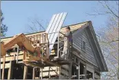  ?? Photos by Kristina Wilder,
Rome News-Tribune ?? LEFT: A crew from Tierce Constructi­on removes the tin roof from the Vann Cherokee Cabin in Cave Spring.