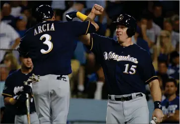  ?? AP PHOTO BY JAE HONG ?? Milwaukee Brewers’ Orlando Arcia celebrates his two-run home run with Erik Kratz (15) during the seventh inning of Game 3 of the National League Championsh­ip Series baseball game against the Los Angeles Dodgers Monday, Oct. 15, in Los Angeles.