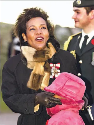  ?? ANDREW VAUGHAN/ CP ?? Governor General Michaëlle Jean shields her daughter Marie-Eden from the wind at a ceremony in Charlottet­own yesterday.