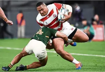  ??  ?? Going all out: Japan’s Asaeli Ai Valu (right) is tackled by South Africa’s Cheslin Kolbe during the Rugby World Cup quarter-finals at the Tokyo Stadium on Sunday. South Africa won 26-3. — AFP