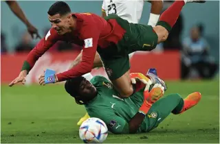  ?? AFP PHOTO ?? Portugal forward Cristiano Ronaldo collides with Ghana goalkeeper Lawrence Ati Zigi during the Qatar 2022 World Cup Group H football match between Portugal and Ghana at Stadium 974 in Doha on Thursday, Nov. 24, 2022.