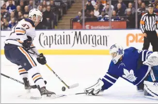  ?? The Canadian Press ?? Toronto Maple Leafs goaltender Curtis McElhinney makes a poke-check save on Edmonton Oilers centre Connor McDavid during first-period NHL action in Toronto on Sunday. The Leafs won 1-0.