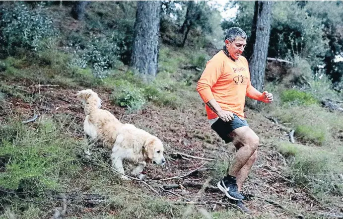  ?? XAVIER CERVERA ?? El conseller d’Interior, Miquel Sàmper, ahir corrent sota la pluja amb el Pinxo, el gos de la família, als voltants de casa seva