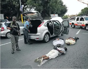  ?? Picture: Alon Skuy ?? In many instances, simply increasing arrest rates does not automatica­lly produce a safer society. Here, police guard three suspected hijackers on Oxford Road, Johannesbu­rg, in 2009.