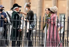  ?? SWNS ?? Hollywood star Dakota Johnson, second from right, in Bath filming the new Netflix adaptation of Jane Austen’s novel Persuasion