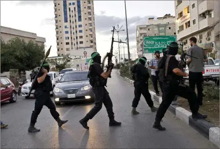  ?? LYNSEY ADDARIO/THE NEW YORK TIMES ?? Fighters with Hamas’ military wing, the Qassam Brigades, are shown in 2011 in Gaza City. Israel has vowed time and again to dismantle the deeply entrenched military and political group, but that goal may not even be possible.