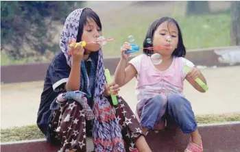  ?? — Reuters ?? Evacuees blow soap bubbles as they play in an open area of the evacuation centre at Saguiran village in Lanao Del Sur, Philippine­s, on Saturday.