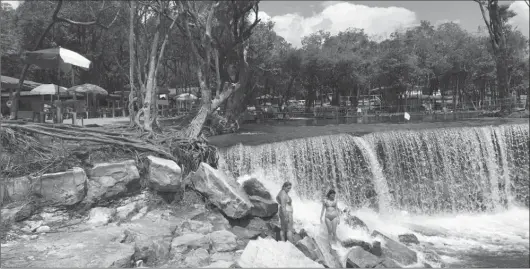  ??  ?? Amazon dwellers and tourists enjoy a waterfall on a tributary of the Rio Negro outside of Manaus. Many people live along the hundreds of large tributarie­s that feed into the main rivers in the Amazon basin.