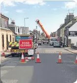  ??  ?? Sandy, left, has now been reconnecte­d after the BT pole was replaced. Above, a crane lifts the pole over the houses.