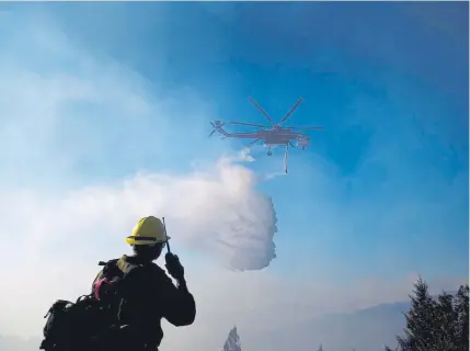  ?? Noah Berger, Associated Press file ?? A helicopter drops water while battling the Kincade fire near Healdsburg, Calif., last fall. As wildfire risks heat up, startups in California’s Silicon Valley are starting to take notice.