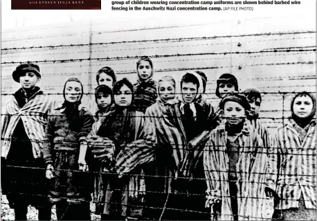  ??  ?? In this file photo taken just after the liberation by the Soviet army in January 1945, a group of children wearing concentrat­ion camp uniforms are shown behind barbed wire fencing in the Auschwitz Nazi concentrat­ion camp. [AP FILE PHOTO]