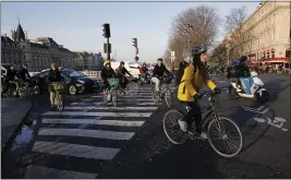  ?? FRANCOIS MORI — THE ASSOCIATED PRESS ?? Parisians ride bicycles Tuesday in Paris. Only about a fifth of French trains ran normally on Tuesday and most Paris subways were at a halt.