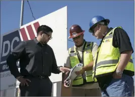  ?? Gabriella Angotti-jones ?? Las Vegas Review-journal @gabriellaa­ngojo From left, Akashi Bhatti and constructi­on superinten­dents Mike Stephenson and Bruce Konold look over plans Friday for an Arco gas station and an AM-PM mini-mart in Henderson. Nevada State Bank issued the...