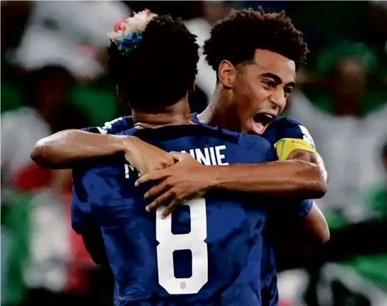  ?? PATRICK T. FALLON/AFP ?? Tyler Adams leaps into the arms of teammate Weston McKennie after the US took a 1-0, first-half lead over Iran.