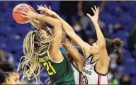  ?? Elsa / TNS ?? Baylor’s DiJonai Carrington (21) tries to take a shot as UConn’s Aaliyah Edwards (3) and Olivia Nelson-Ododa (20) defend in the final minutes of the game of the Women’s NCAA Tournament on Monday.