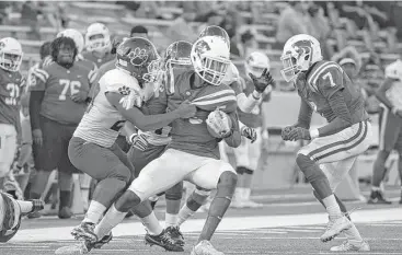  ?? Jerry Baker ?? Cy Creek junior wideout Miles Battle, center, tries to break free of the grasp of Cy-Fair senior defensive back Dylan Higgins, left, during their District 17-6A matchup.