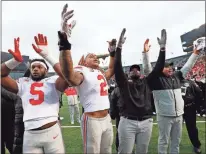  ?? AP-Paul Sancya, File ?? Ohio State’s Baron Browning (5), Chase Young (2), linebacker­s coach Al Washington and head coach Ryan Day celebrate after a victory over Michigan in an NCAA college football game in Ann Arbor, Mich.