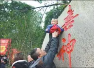  ?? ZHANG GUOFANG / FOR CHINA DAILY ?? A father lifts his child to touch the character xi (happiness), to wish the family well for the Chinese New Year.