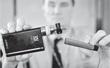  ?? STEVEN SENNE/AP ?? Robert Keuther, principal of Marshfield High School in Marshfield, Mass., displays vaping devices (including a Juul, right) that have been confiscate­d from students at the school.