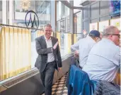  ?? MARK MIRKO/HARTFORD COURANT ?? Scott Smith, chief executive officer of Max Hospitalit­y LLC, waves to diners at the bar at Max Downtown in Hartford.