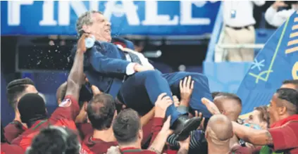  ?? REUTERS ?? Portugalci bacaju u zrak svog izbornika Fernanda Santosa nakon osvajanja Eura