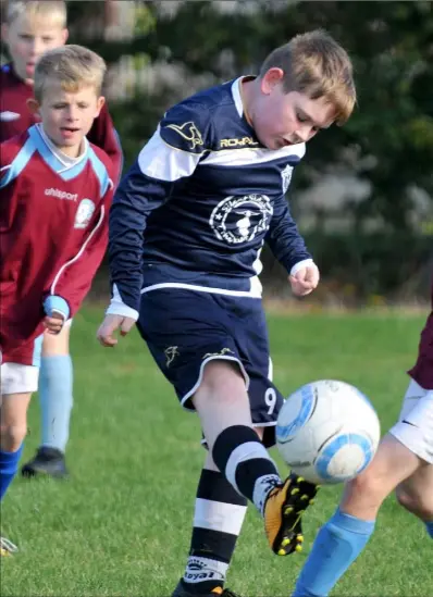  ??  ?? Callum Watters clears for Ardee Athletic as Michael Kirby challenges for St. Dominic’s.