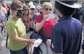  ?? SETH WENIG — THE ASSOCIATED PRESS ?? Tennis fans show their proof of vaccinatio­n cards for entry to the U.S. Open tennis championsh­ips on Monday.