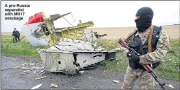  ?? Pictures: MAXIM ZMEYEV / REUTERS ?? A pro-Russia separatist with MH17 wreckage