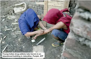  ??  ?? Young Indian drug addicts take heroin in an abandoned building in Jalandhar, Punjab. AFP