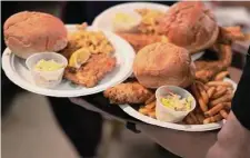 ?? Photos by Jessie Wardarski/Associated Press ?? Plates of fried fish and sides were delivered Feb. 24 at the Allegheny Elks Lodge No. 339 during its annual fish fry on the first night of Lent in Pittsburgh.