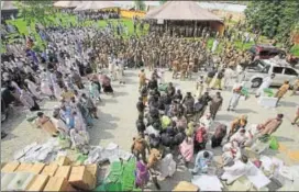  ?? AP ?? Big brother watching: Election staff receive polling material in Peshawar as soldiers look on.