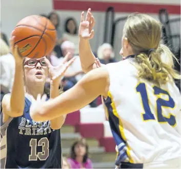  ?? JULIE JOCSAK/STANDARD STAFF ?? Emma Holloway of the Blessed Trinity Thunder shoots the ball past Janee Harrison of the Sir Winston Churchill Bulldogs during the Standard Girls Basketball Tournament at Governor Simcoe on Thursday.