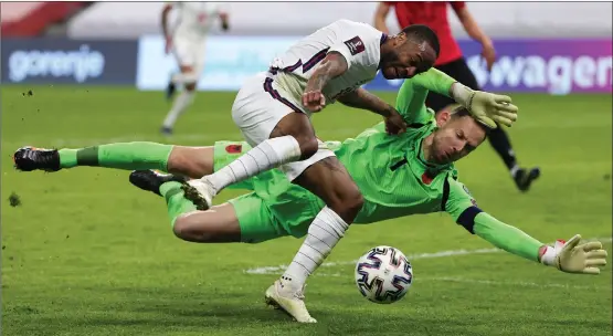  ??  ?? Albania goalkeeper Etrit Berisha challenges England winger Raheem Sterling during the Three Lions’ victory in Tirana last night