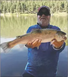  ?? COURTESY NEW MEXICO DEPARTMENT OF GAME AND FISH ?? Phillip Martinez, Sr. of Albuquerqu­e caught a 20-inch rainbow trout using a wax worm Sept. 5 at Fenton Lake.