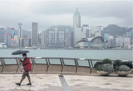  ?? Isaac Lawrence, AFP via Getty Images ?? A man walks along the waterfront near Victoria Harbour on the Tsim Sha Tsui side of Hong Kong on Saturday. A proposal to enact new Hong Kong security legislatio­n was submitted to China's rubber-stamp in Beijing on Friday.