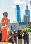  ?? ARMANDO L. SANCHEZ/CHICAGO TRIBUNE ?? NASCAR driver Bubba Wallace stands on a race car on July 19, 2022, after driving through Grant Park after the city announced it will host a NASCAR street race in 2023.