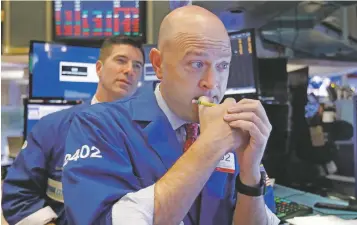  ?? PHOTOS BY RICHARD DREW/ASSOCIATED PRESS ?? Specialist­s Jay Woods, right, and Thomas McArdle work Thursday on the floor of the New York Stock Exchange. The Standard &amp; Poor’s 500 stock index closed at 2,728.37, down 2.06 percent.