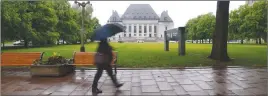  ?? CP PHOTO ?? A pedestrian walks in the rain past the Supreme Court of Canada in Ottawa.