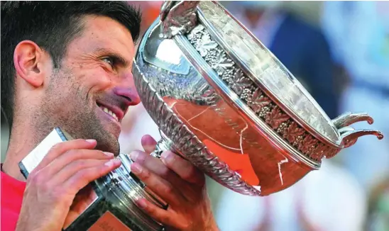  ??  ?? Novak Djokovic sonríe con su segunda Copa de los Mosquetero­s en las manos