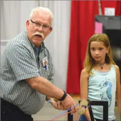  ?? NEWS PHOTO EMMA BENNETT ?? Bob Findlay and his young helper Bridget Lewendon demonstrat­e how to make a rope at Country in the City at the Stampede grounds.