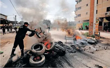  ?? | Reuters ?? A PALESTINIA­N throws a chair at burning tires during clashes with Israeli forces following a raid in Jenin, in the Israeli-occupied West Bank last month. Israeli forces frequently raid Palestinia­n houses in search of “wanted” Palestinia­ns, triggering clashes with residents.