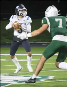  ?? DOUG HASTINGS / LOWELL SUN ?? Wilmington High quarterbac­k Jacob Rogue scans the field as he’s pressured by Billerica’s Scott Einarson. Billerica won 35-7.