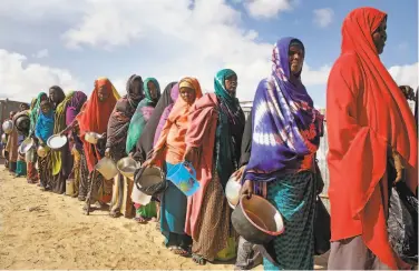  ?? Farah Abdi Warsameh / Associated Press ?? Somali women fleeing drought line up in May to receive food at a camp outside the capital, Mogadishu.